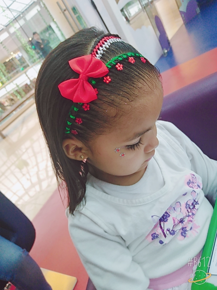 Niña con trenzas rosa y dorado